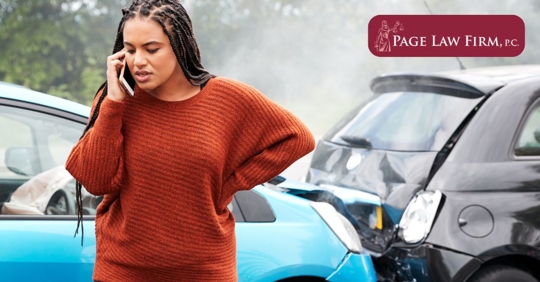 woman on the phone beside a car crash